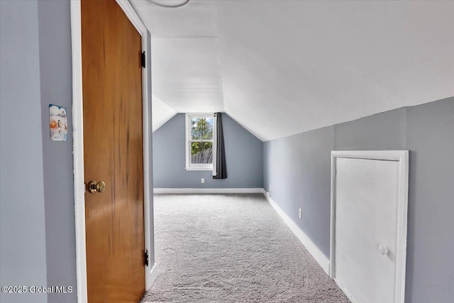 additional living space featuring carpet flooring, vaulted ceiling, and baseboards