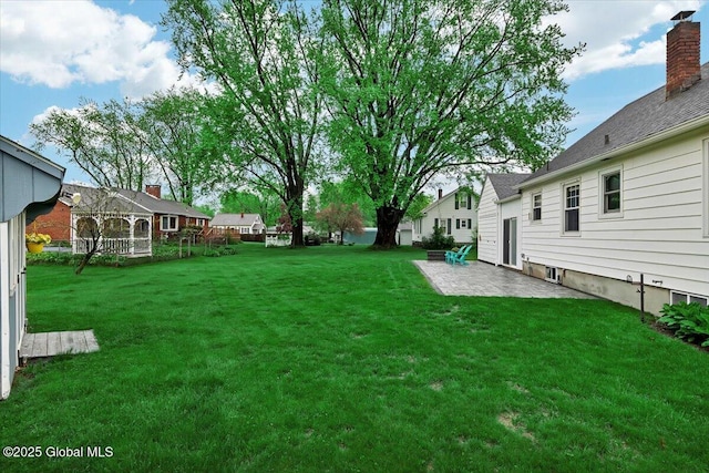 view of green lawn featuring a patio area and a residential view