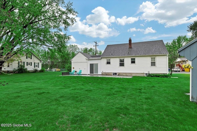 rear view of house with a patio, a chimney, and a lawn
