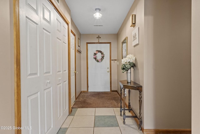 entryway featuring baseboards and light colored carpet
