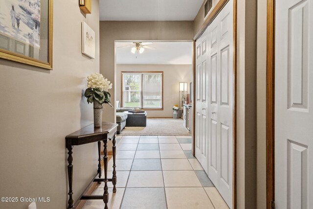 corridor with light colored carpet, light tile patterned floors, and baseboards