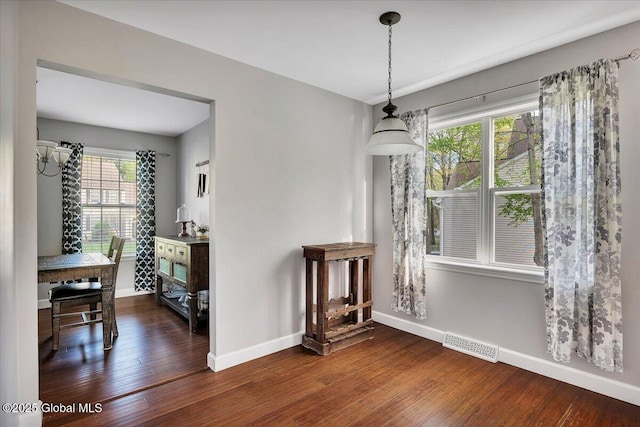 dining space with baseboards and wood finished floors