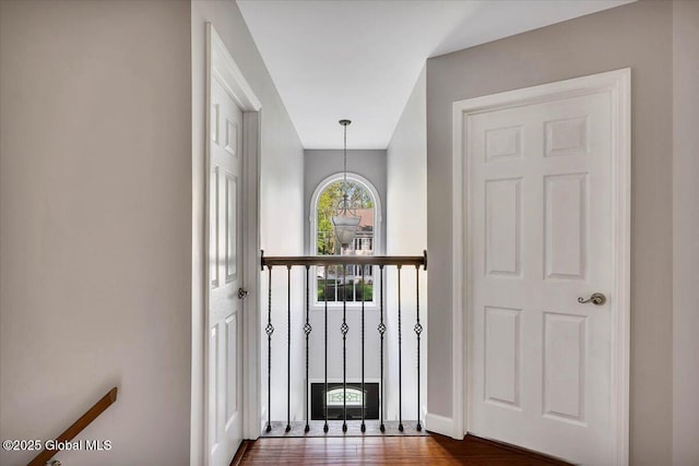 doorway with dark wood finished floors, baseboards, and a chandelier