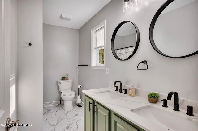bathroom featuring marble look tile flooring, toilet, double vanity, and baseboards