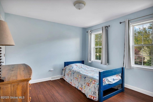 bedroom with wood finished floors and baseboards