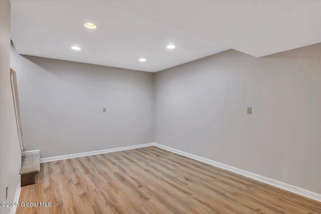 finished basement featuring light wood-type flooring, recessed lighting, and baseboards