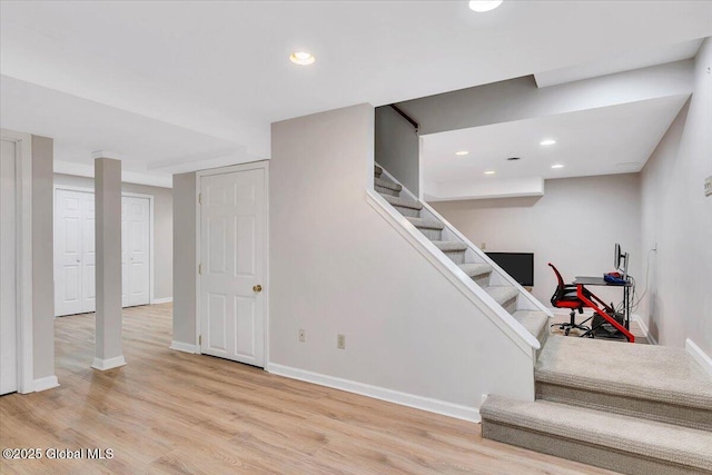 stairway featuring baseboards, wood finished floors, and recessed lighting
