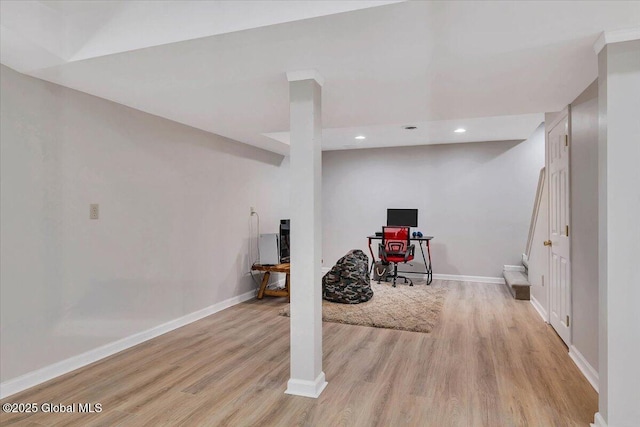 finished below grade area with light wood finished floors, recessed lighting, and baseboards