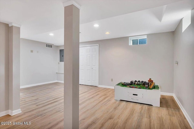 basement with wood finished floors, baseboards, recessed lighting, and electric panel