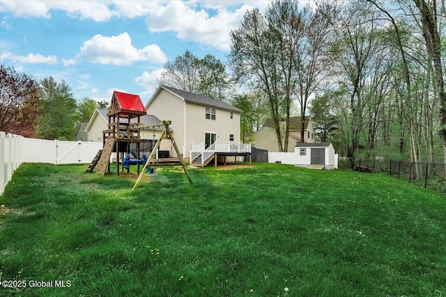 back of house with a playground, a deck, a shed, and an outdoor structure