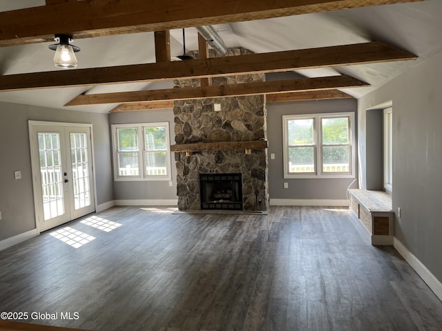 unfurnished living room with baseboards, a healthy amount of sunlight, and vaulted ceiling with beams