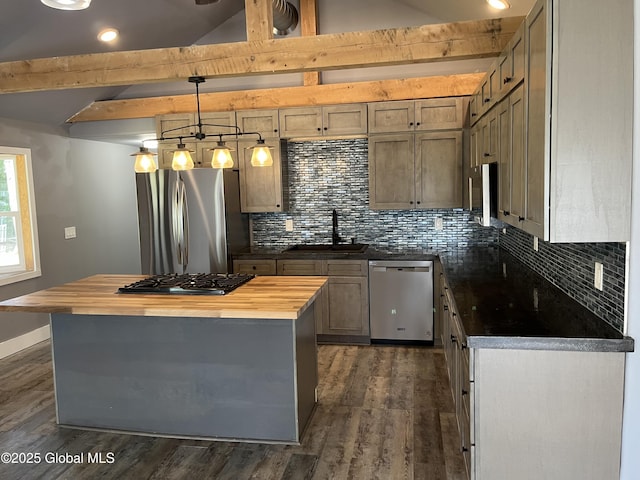 kitchen with wooden counters, a center island, a sink, stainless steel appliances, and tasteful backsplash
