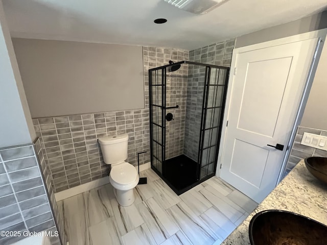 full bath featuring tile walls, toilet, visible vents, a shower stall, and vanity