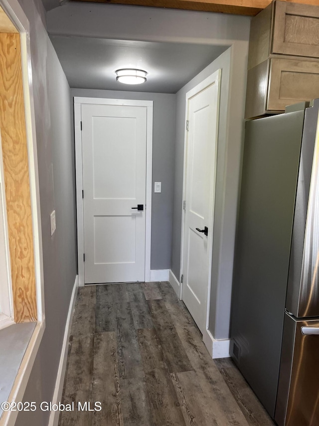 doorway featuring baseboards and dark wood-style flooring