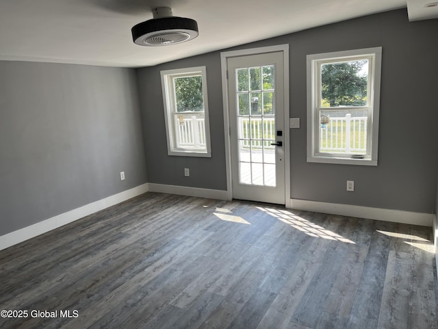doorway to outside featuring baseboards and dark wood finished floors
