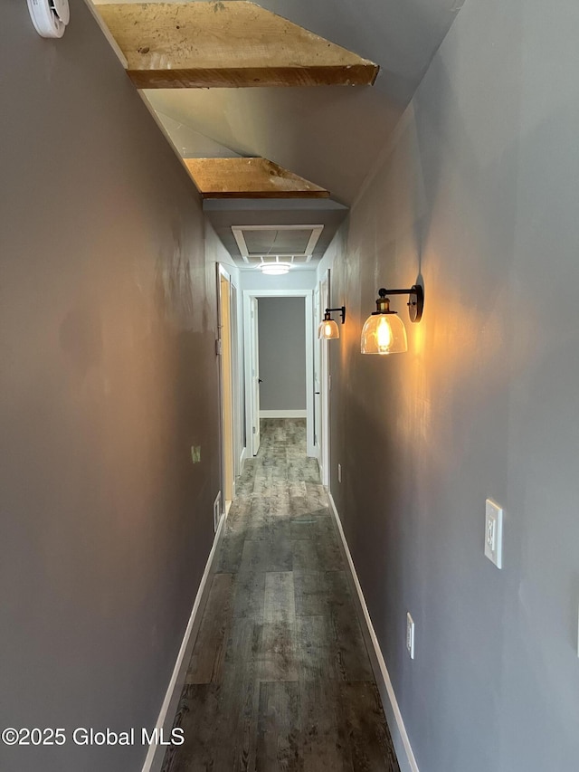 hallway featuring baseboards, visible vents, and wood finished floors