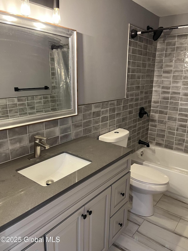 bathroom with shower / bathing tub combination, vanity, toilet, and backsplash