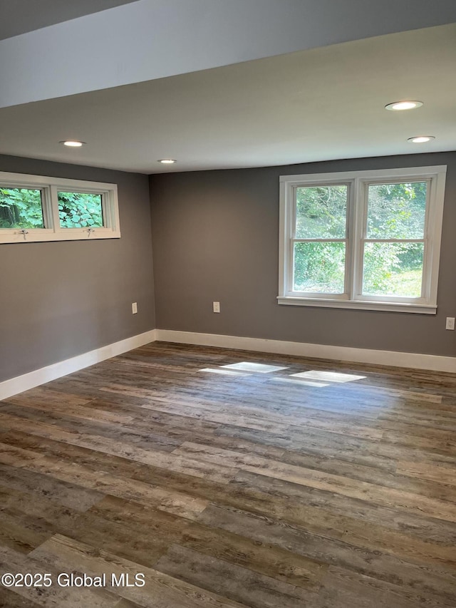 spare room featuring baseboards, dark wood-style flooring, and recessed lighting
