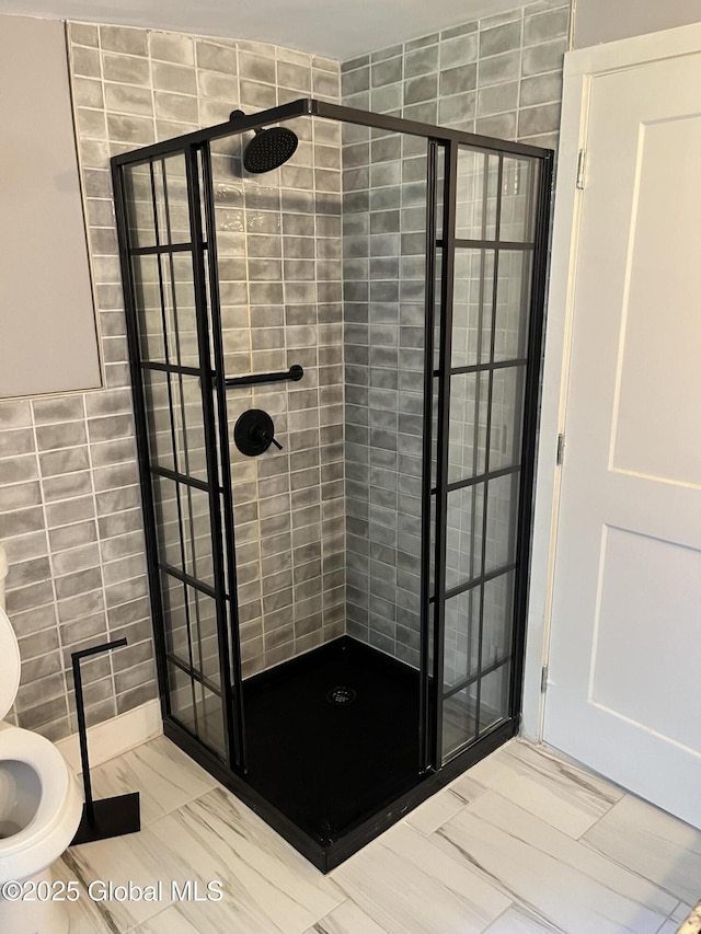 full bathroom with a stall shower, tile walls, and toilet
