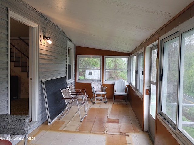 sunroom / solarium featuring a wealth of natural light, baseboards, and lofted ceiling