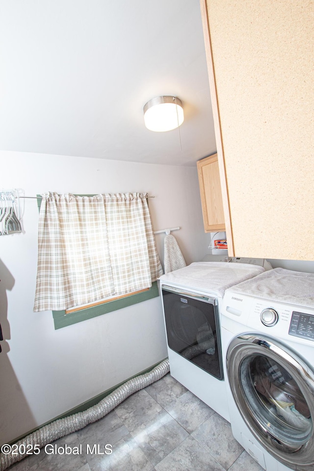 clothes washing area with washing machine and clothes dryer and cabinet space