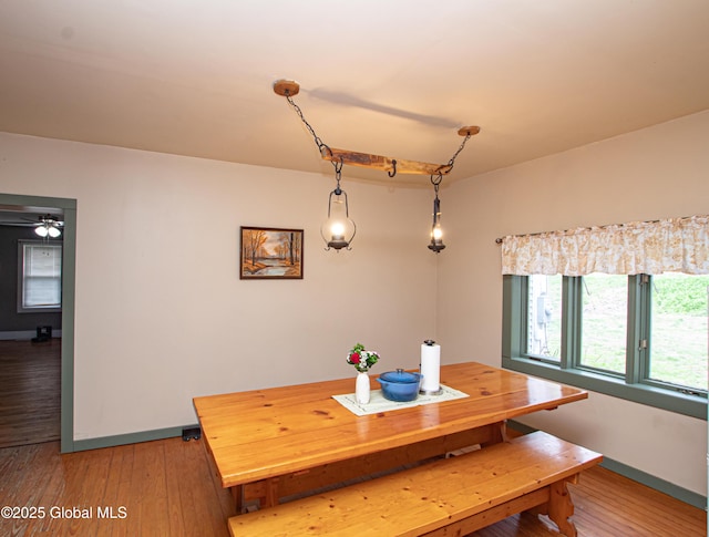 dining space featuring light wood-type flooring and baseboards