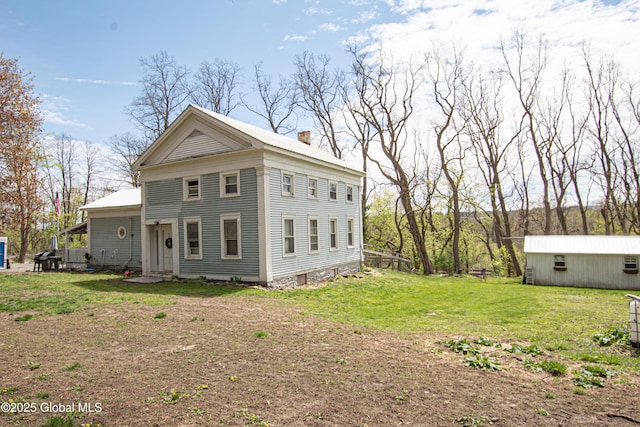 view of property exterior with a chimney and a lawn