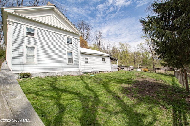 view of home's exterior featuring a yard and fence