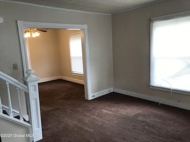 23 Orville St, Glens Falls, NY 12801 - empty room featuring dark carpet, ornamental molding, ceiling fan, baseboards, and stairway