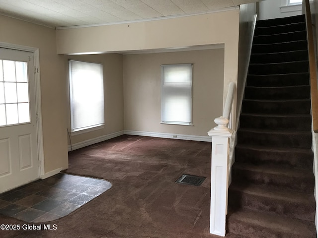 23 Orville St, Glens Falls, NY 12801 - entrance foyer with dark colored carpet, stairway, plenty of natural light, ornamental molding, and baseboards