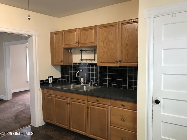 23 Orville St, Glens Falls, NY 12801 - kitchen featuring dark countertops, a sink, backsplash, and brown cabinetry
