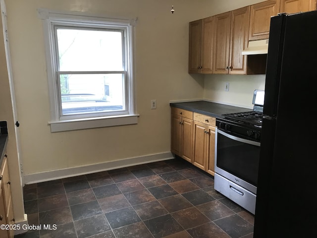 23 Orville St, Glens Falls, NY 12801 - kitchen featuring freestanding refrigerator, stainless steel gas stove, under cabinet range hood, baseboards, and dark countertops