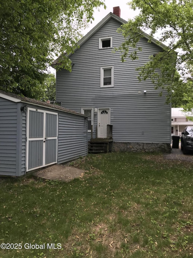 23 Orville St, Glens Falls, NY 12801 - rear view of house featuring a lawn and a chimney
