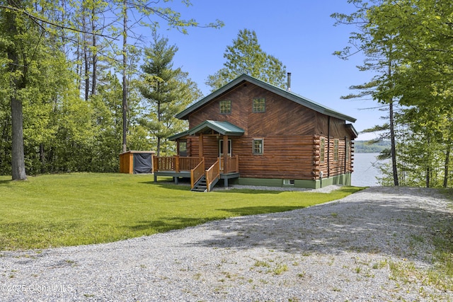 89 Captains Cv, Crown Point, NY 12928 - view of front of house with a storage unit, log exterior, an outdoor structure, a front yard, and driveway