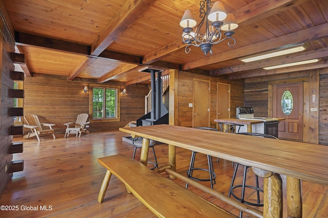89 Captains Cv, Crown Point, NY 12928 - dining area with wood walls, beam ceiling, wooden ceiling, hardwood / wood-style flooring, and a chandelier