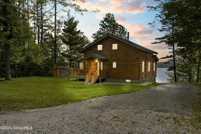89 Captains Cv, Crown Point, NY 12928 - view of front of home with log siding, a storage unit, an outdoor structure, a lawn, and gravel driveway