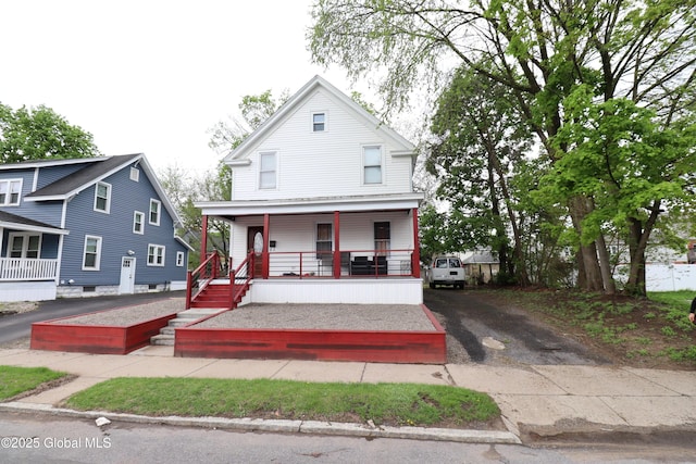 american foursquare style home with covered porch and driveway