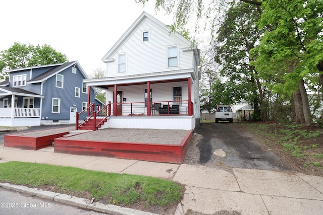 american foursquare style home featuring covered porch and driveway