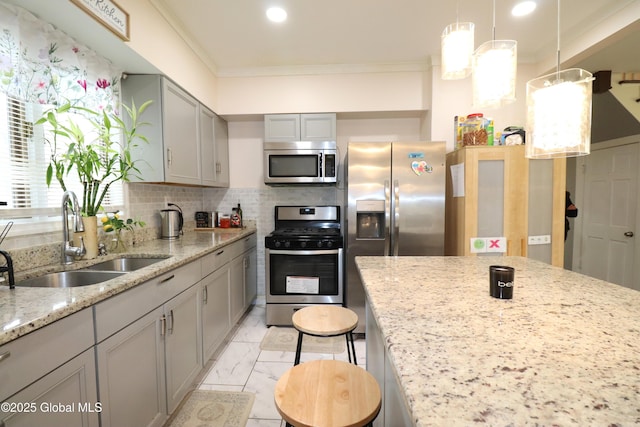 kitchen with appliances with stainless steel finishes, a sink, gray cabinetry, light marble finish floors, and ornamental molding