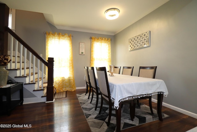 dining area featuring hardwood / wood-style floors, stairs, baseboards, and ornamental molding