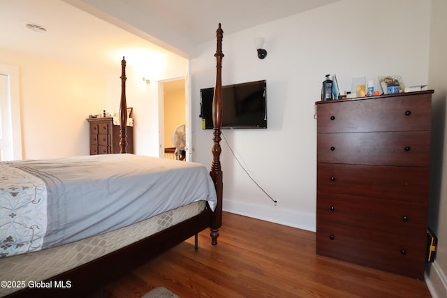 bedroom with wood finished floors and baseboards