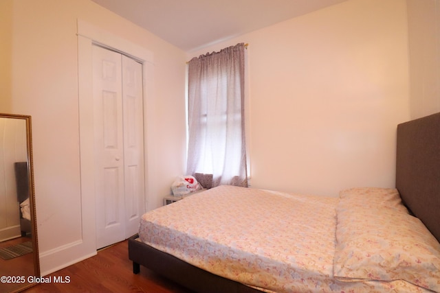 bedroom with wood finished floors and a closet