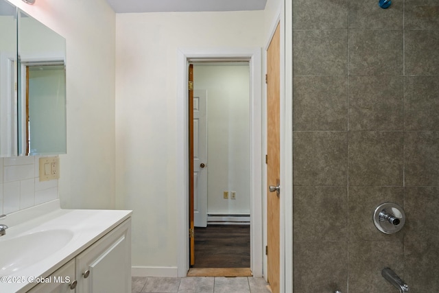 bathroom with walk in shower, vanity, tile patterned flooring, baseboard heating, and baseboards