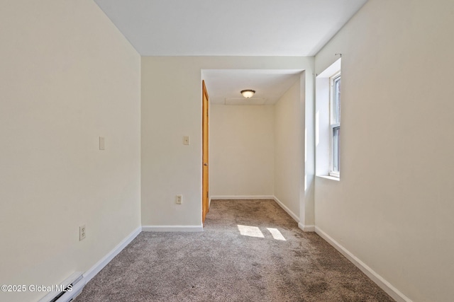 carpeted spare room featuring baseboards and a baseboard radiator