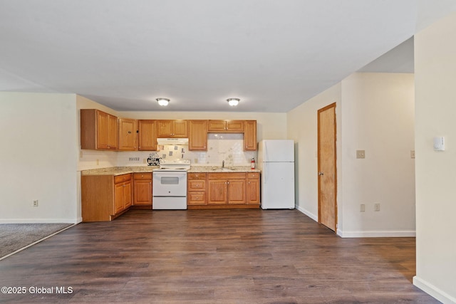 kitchen featuring a sink, dark wood-type flooring, baseboards, white appliances, and under cabinet range hood
