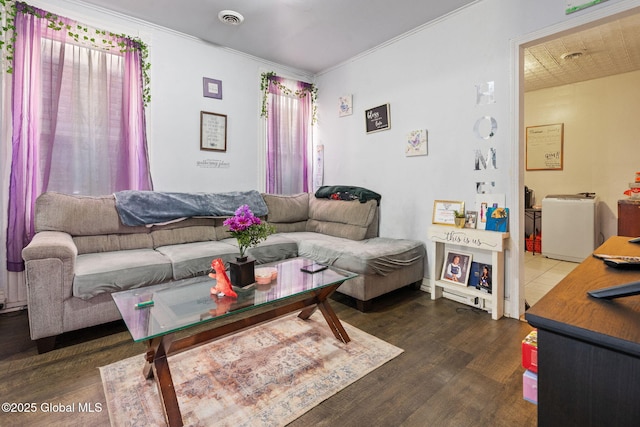 living area featuring ornamental molding, visible vents, and wood finished floors