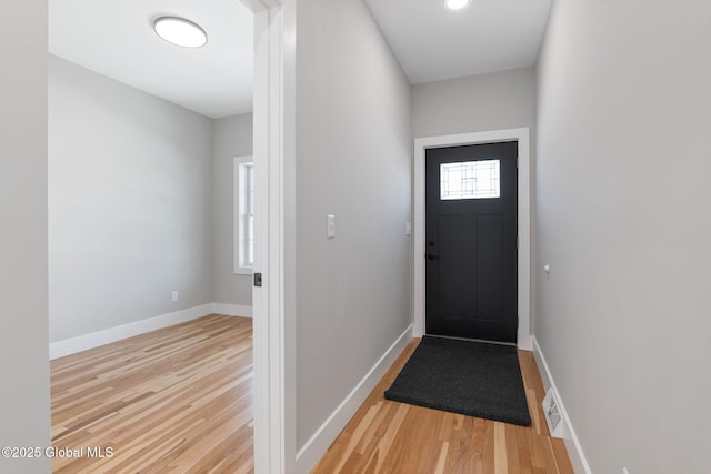 doorway to outside with baseboards and wood finished floors