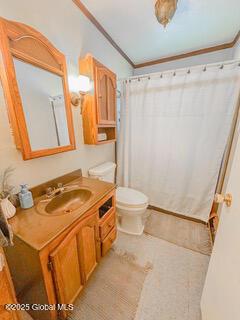 full bath featuring toilet, vanity, crown molding, and a shower with shower curtain