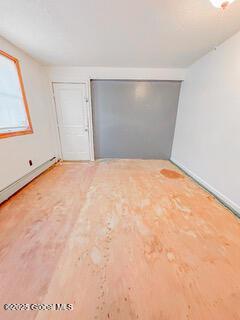 spare room featuring baseboards and wood finished floors