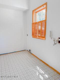 unfurnished room featuring tile patterned floors and baseboards